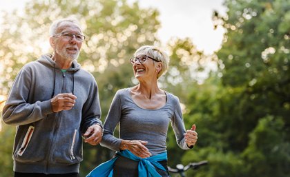 Older couple smiling and jogging. Adobe